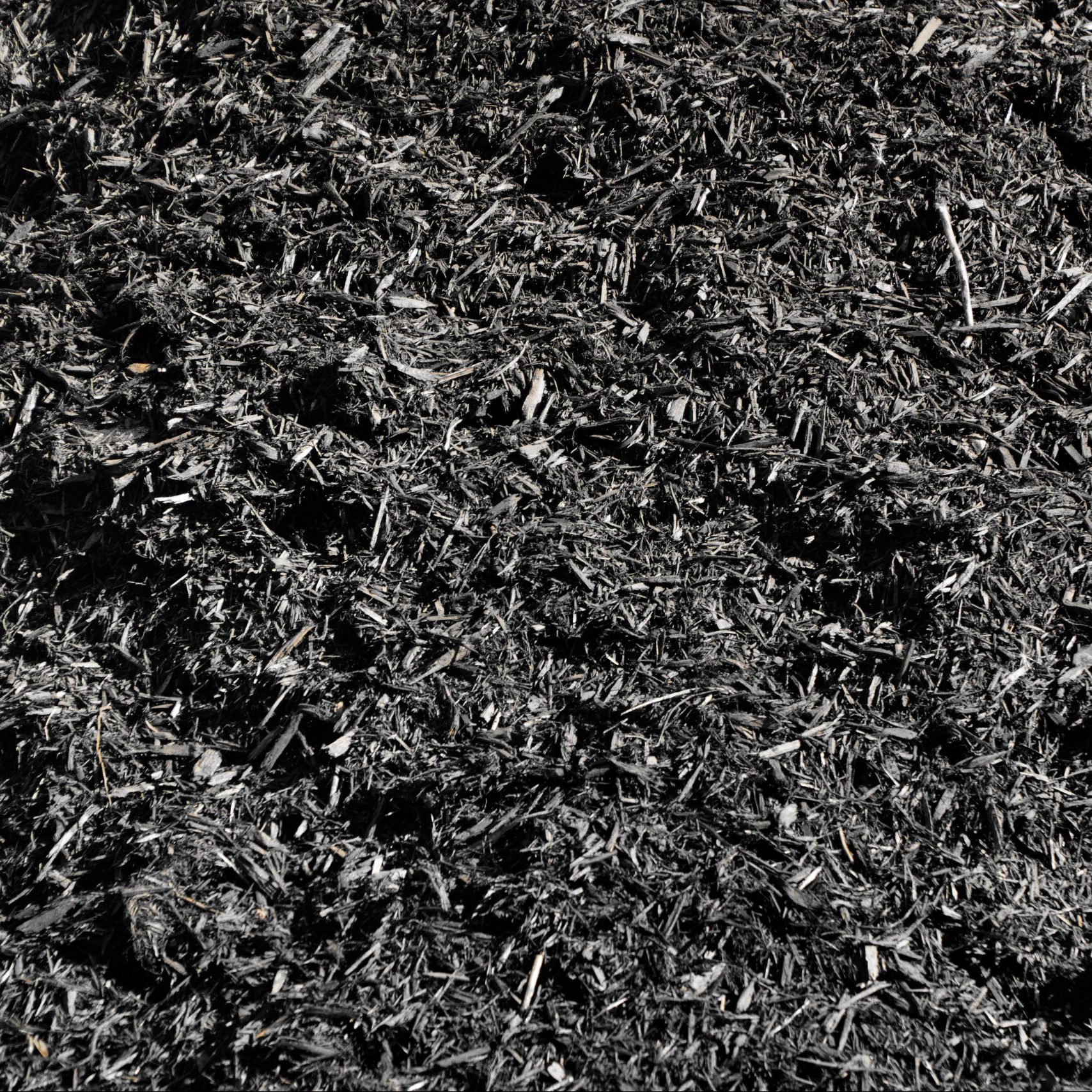 A large pile of wood chips, dyed black